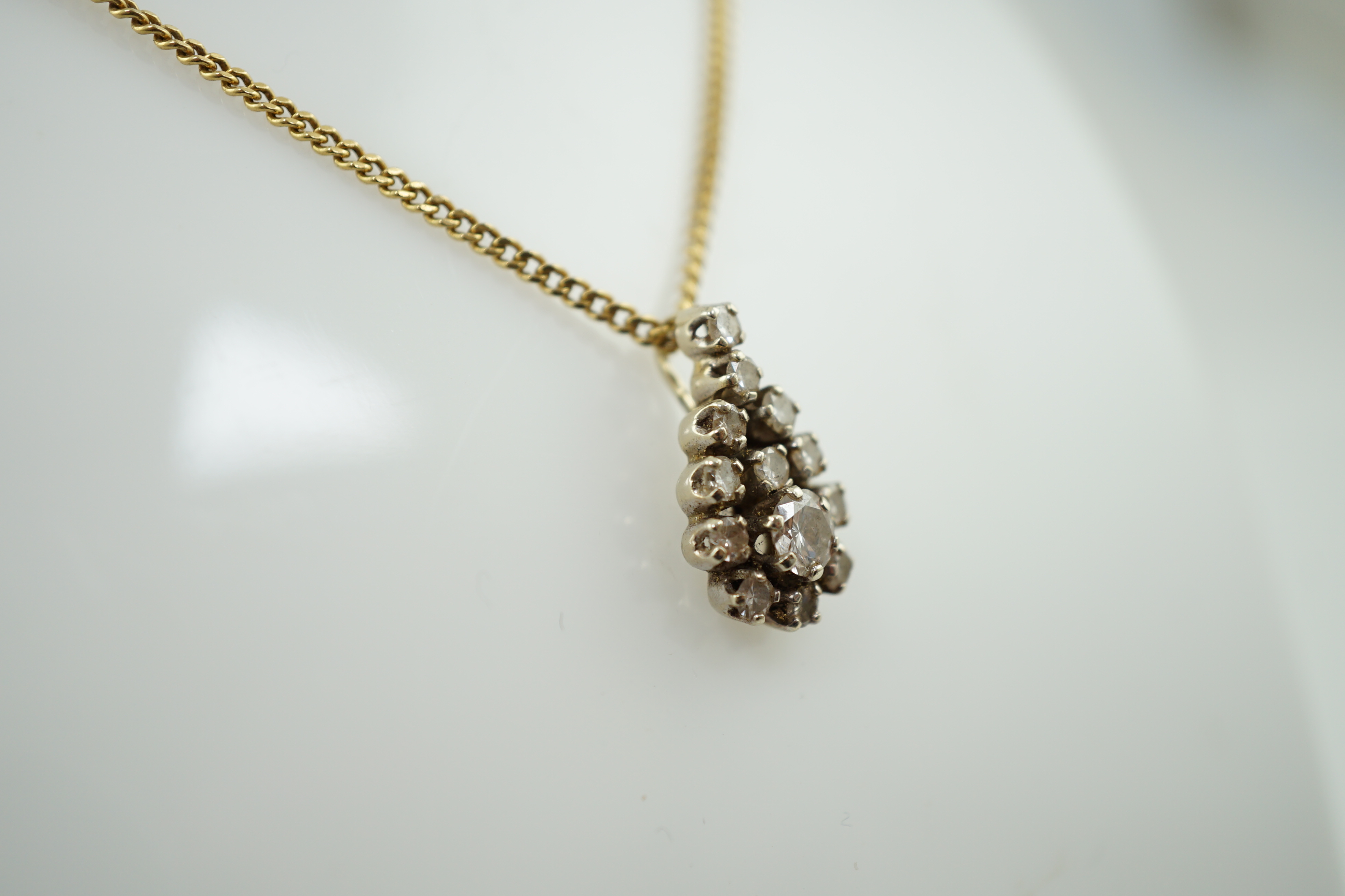 An early to mid 20th century French 18k gold and diamond cluster set pendant, on a French 18k gold chain